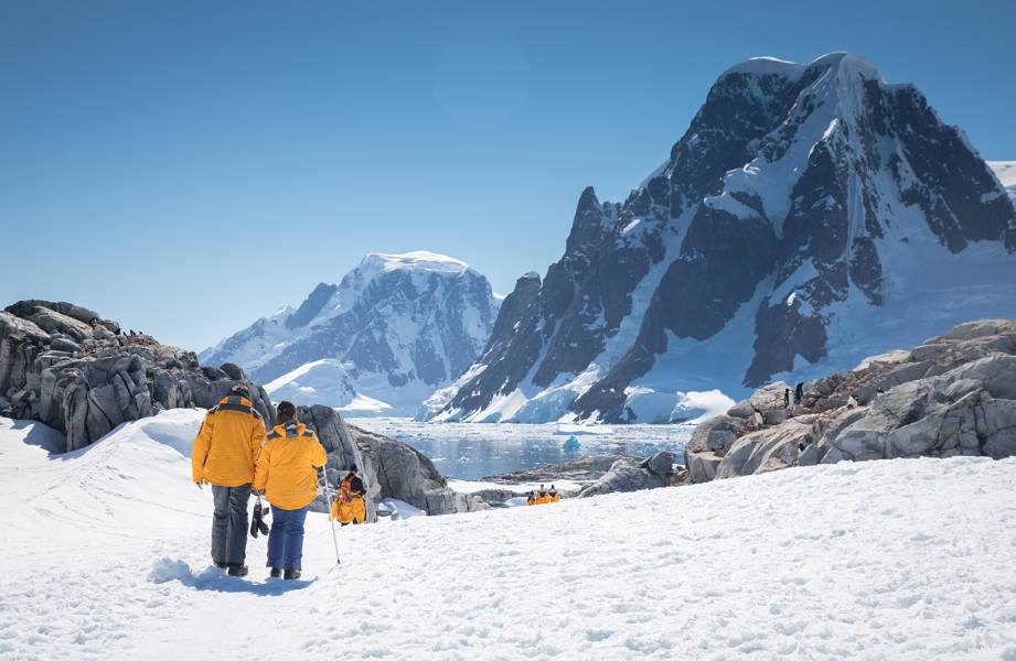 Guests hike through the snow at Petermann Island in the Antarctica Peninsula.