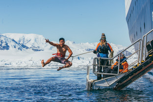 A guest jumps off the gangway (with a safety harness) into Antarctic waters during the Polar Plunge.