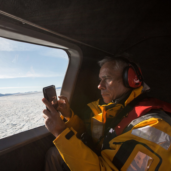 Passenger taking a photo of Arctic landscape from helicopter
