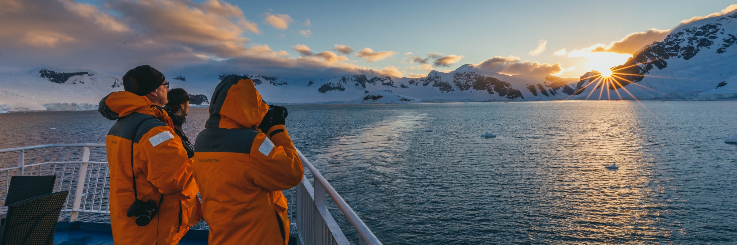 Guests photographing the Antarctic landscapes from the deck of their expedition vessel. Photo by David Merron.